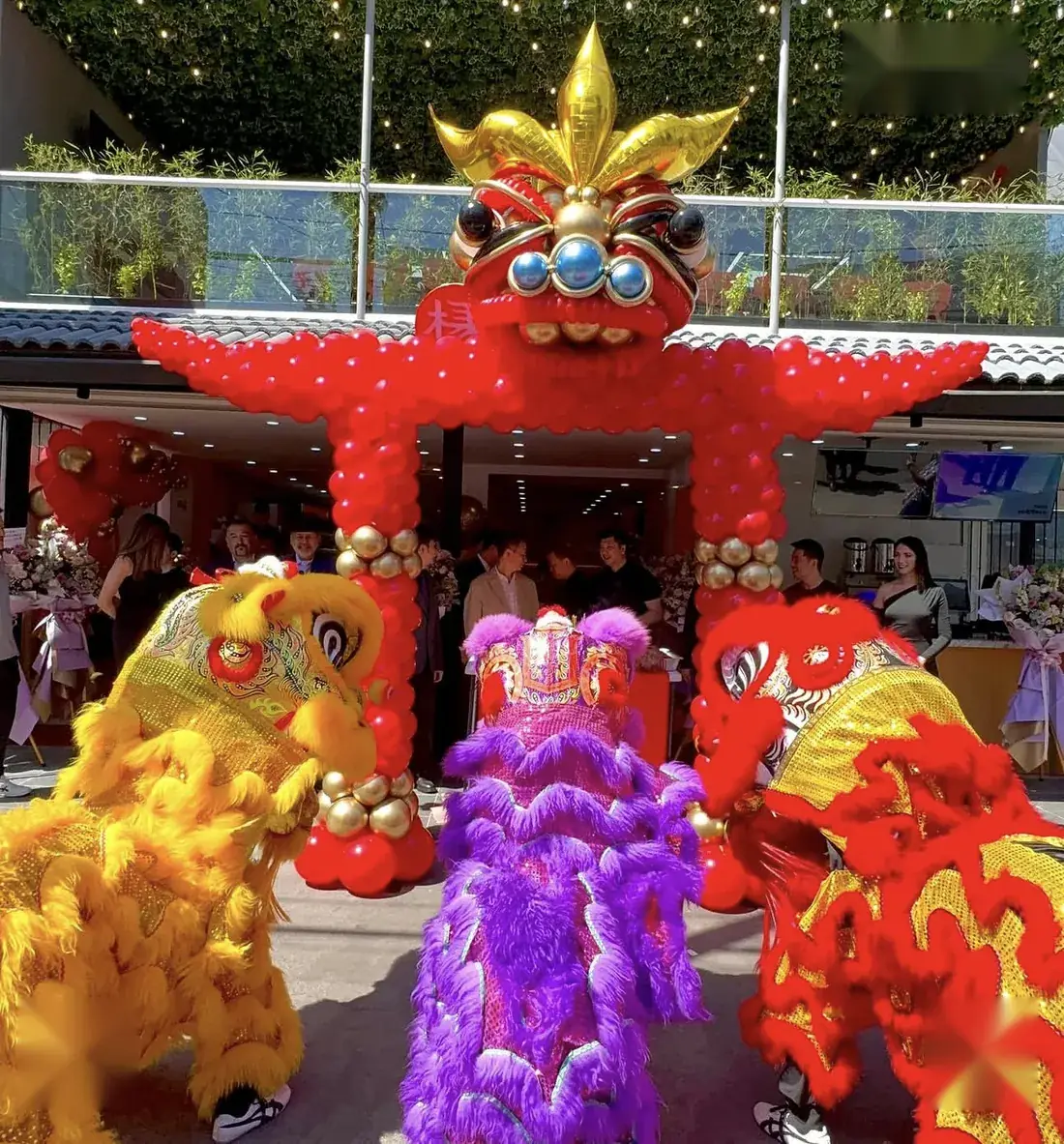 Arco de globos rojos y dorados con danza de leones en la inauguración de un local en Polanco